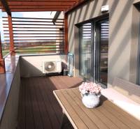 Na predaj štyri apartmány na jednom poschodí Podhájská - Terasa 2-izbového bytu s výhľadom na okolie a kvetinovou dekoráciou.