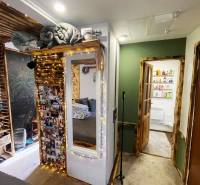 Bývanie v prírode, na dosah mesta, murov. chatka s celoročným využitím - Interiér rodinného domu s osvetlenými dekoráciami, zrkadlom a fotografiami na stene.