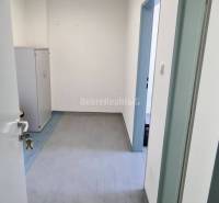 Dobré reality-na prenájom priestory 48,4 m2 a 30,90m2+ kúpelňa s wc, p - Interiér kancelárie s bielymi stenami, zamykateľnou skrinkou a podlahou s dreveným dekorom.