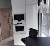 Na prenájom pekný 3izbový byt po rekonštrukcii 800,- Eur - Kuchyňa v 3-izbovom byte so vstavanými spotrebičmi a čiernym stolom.