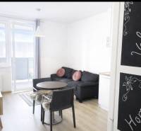 Na predaj 1,5 izbový apartmán v BA III Malokrasňanská 42,34m2 - Obývačka v 2-izbovom byte s podlahou s dreveným dekorom a balkónom.