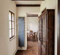 Vymeňte mestský hluk za ticho Bystričky: Domček s dušou a potenciálom - Drevené trámy, podlaha s dreveným dekorom a starožitná skriňa v rodinnom dome.