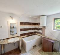 Vymeňte mestský hluk za ticho Bystričky: Domček s dušou a potenciálom - Kúpeľňa v rodinnom dome s umývadlom, vaňou a bojlerom.