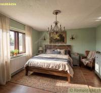 Vymeňte mestský hluk za ticho Bystričky: Domček s dušou a potenciálom - Spálňa s rustikálnym nábytkom, podlaha s dreveným dekorom a veľkým oknom v rodinnom dome.