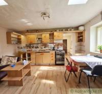 Vymeňte mestský hluk za ticho Bystričky: Domček s dušou a potenciálom - Kuchyňa v rodinnom dome s podlahou s dreveným dekorom, svetlý interiér a jednoduchý nábytok.