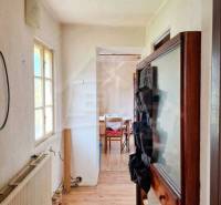 Vymeňte mestský hluk za ticho Bystričky: Domček s dušou a potenciálom - Interiér rodinného domu s úzkou chodbou a miestnosťou na konci.