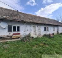 Vymeňte mestský hluk za ticho Bystričky: Domček s dušou a potenciálom - Rodinný dom v Ozdíne s bielou fasádou a satelitnou anténou na streche.