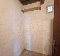 Vymeňte mestský hluk za ticho Bystričky: Domček s dušou a potenciálom - Malá izba s betónovou podlahou v rodinnom dome, drevený strop, jednoduché steny.