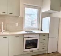 Na predaj 2 izbový murovaný domček, Bratislava, Záhorská Bystrica - Kuchyňa v 2-izbovom byte s umývadlom, rúrou a bielou chladničkou.