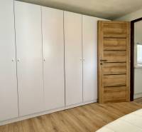 Na predaj 2 izbový murovaný domček, Bratislava, Záhorská Bystrica - Biela vstavaná skriňa, dvere s dreveným dekorom, pohľad do kuchyne v 2-izbovom byte.