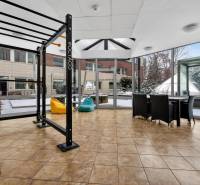 Kancelárie od 20m2 na PRENÁJOM | TOP biznis lokalita - Fitness zariadenie a sedenie s výhľadom v Kancelárii, podlaha s dreveným dekorom.