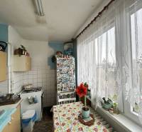 NA PREDAJ 3-IZBOVÝ BYT  S LODŽIOU, 67m2,  OKTÓBROVÁ ul,, PREŠOV - Kuchyňa 3-izbového bytu s veľkým oknom, záclonou a kvetmi na parapete.