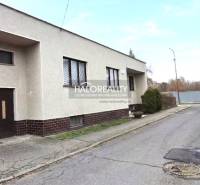 Predaj, rodinný dom Poltár - EXKLUZÍVNE HALO REALITY - Rodinný dom v meste Poltár s rovnou strechou a garážou pri ceste.