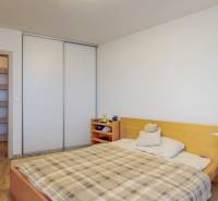 2 byty v 1 už s nájomníkmi | okamžitý príjem 1600 €/mes | 4.87% - Spálňa v 3-izbovom byte s podlahou v dekore dreva, posteľou a pracovným stolom.