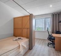 4-izbový nízkoenergický dom s pozemkom 600m2 | Alžbetin Dvor - Spálňa s pracovným stolom a posteľou, podlaha s dreveným dekorom. Rodinný dom interiér.