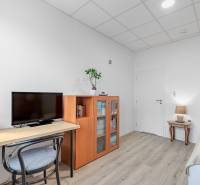 4-izbový nízkoenergický dom s pozemkom 600m2 | Alžbetin Dvor - Izba v rodinnom dome s televízorom, knihovničkou a podlahou s dreveným dekorom.