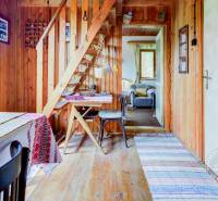 Dvojpodlažná chata v krásnom prostredí Buková, okr. Trnava - Drevená chata s drevenými stenami, schodiskom a stolom, útulné sedenie.