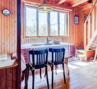 Dvojpodlažná chata v krásnom prostredí Buková, okr. Trnava - Drevený interiér chaty s jedálenským stolom, stoličkami a dekoratívnymi prvkami v tradičnom štýle.