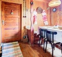 Dvojpodlažná chata v krásnom prostredí Buková, okr. Trnava - Rustikálny interiér chaty s drevenými stenami a tradičnými výšivkami na dečkách.