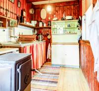 Dvojpodlažná chata v krásnom prostredí Buková, okr. Trnava - Kuchyňa v chate s dreveným obložením, varičom a riadom.