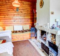 Dvojpodlažná chata v krásnom prostredí Buková, okr. Trnava - Interiér chaty so sedačkou a kozubom, s dreveným obložením steny.