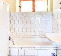 Dvojpodlažná chata v krásnom prostredí Buková, okr. Trnava - Kúpeľňa v chate s vaňou, umývadlom a bojlerom, obložená bielymi kachličkami.