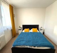 Pekný zariadený 3 izbový byt s lodžiou, Púpavová ulica, BA.Karlova Ves - Spálňa s posteľou, žltými vankúšmi a modrou prikrývkou v 3-izbovom byte.