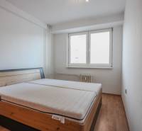 Na prenájom 2 izbový byt v Piešťanoch - Spálňa s posteľou a podlahou s dreveným dekorom v 2-izbovom byte.