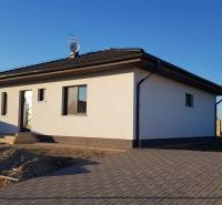 Praktický a úsporný rodinný dom v Bernolákove, Jelšova - Rodinný dom na Jelšovej ulici v Bernolákove s bielo-šedou fasádou a dvorom.