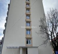 Nový nájomné 1 izbové byty v Prievidzi - ihneď k dispozícii - Bytová budova v Prievidzi na ulici T. Vansovej, pri ktorej parkuje oranžové auto.