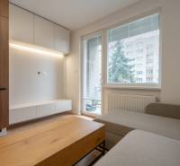 KOMPLETNÁ REKONŠTRUKCIA- 3i 54 m² + balkón - Dubnica nad Váhom - Obývačka v 3-izbovom byte s podlahou s dreveným dekorom, sedačkou a nábytkom.