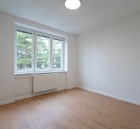 KOMPLETNÁ REKONŠTRUKCIA- 3i 54 m² + balkón - Dubnica nad Váhom - Svetlá izba s bielymi stenami a podlahou s dreveným dekorom v 3-izbovom byte.