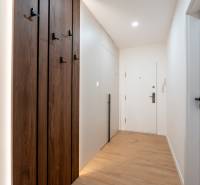 KOMPLETNÁ REKONŠTRUKCIA- 3i 54 m² + balkón - Dubnica nad Váhom - Úzka chodba so vstavanými skrinkami a podlahou s dreveným dekorom v 3-izbovom byte.
