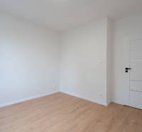 KOMPLETNÁ REKONŠTRUKCIA- 3i 54 m² + balkón - Dubnica nad Váhom - Izba v 3-izbovom byte s podlahou s dreveným dekorom a bielymi stenami.