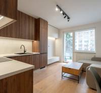 KOMPLETNÁ REKONŠTRUKCIA- 3i 54 m² + balkón - Dubnica nad Váhom - Obývacia izba v 3-izbovom byte s kuchynskou linkou a podlahou s dreveným dekorom.