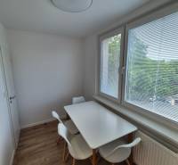 Prenájom 2-izbového bytu Bratislava II, Ružinov - Jedálenský kút v 2-izbovom byte s bielym stolom a stoličkami pri okne.
