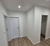 Prenájom 2-izbového bytu Bratislava II, Ružinov - Bielo natretá chodba v 2-izbovom byte s podlahou s dreveným dekorom.