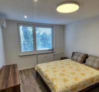 Prenájom 2-izbového bytu Bratislava II, Ružinov - Spálňa v 2-izbovom byte s pohodlnou posteľou a podlahou s dreveným dekorom.