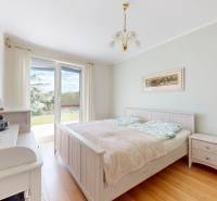 4-izbový dom 132m2 + pozemok 484m2 | Bernolákovo - Spálňa v rodinnom dome s podlahou s dreveným dekorom a výhľadom do záhrady.