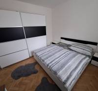 Predaj čiastočne prerobený 3 izbový byt Martin Sever - Spálňa v 3-izbovom byte s veľkou skriňou, manželskou posteľou a podlahou s dreveným dekorom.