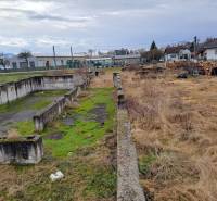 Stavebný pozemok 2 375 m² v obci Valča  - Pozemky - bývanie vo Valči s opustenými betónovými základmi a prírodnou vegetáciou.