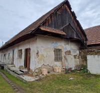 Rodinný dom v obci Háj v pôvodnom stave s veľkým potenciálom - Rodinný dom v Háji s drevenou strechou, omietka poškodená, trávnatý pozemok.