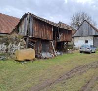 Rodinný dom v obci Háj v pôvodnom stave s veľkým potenciálom - Rodinný dom v Háji s drevenou hospodárskou budovou a zaparkovaným autom na tráve.