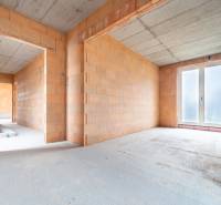 ATRAKTÍVNA MODERNÁ 5 IZB.ROZOSTAVANÁ VILA na KOLIBE - Stavba v interiéri rodinného domu s neomietnutými tehlovými stenami a betónovým stropom.