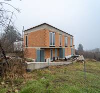 ATRAKTÍVNA MODERNÁ 5 IZB.ROZOSTAVANÁ VILA na KOLIBE - Rodinný dom na Sudovej ulici, Bratislava - Kramáre, s nedokončenou fasádou a veľkými oknami.