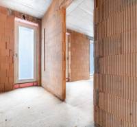 ATRAKTÍVNA MODERNÁ 5 IZB.ROZOSTAVANÁ VILA na KOLIBE - Nedokončený interiér rodinného domu s betónovou podlahou a sklenenými dverami.