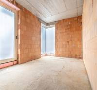 ATRAKTÍVNA MODERNÁ 5 IZB.ROZOSTAVANÁ VILA na KOLIBE - Miestnosť s nedokončenými tehlovými stenami a veľkými oknami v rodinnom dome.