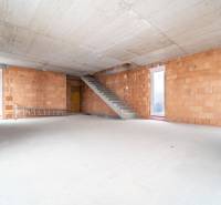 ATRAKTÍVNA MODERNÁ 5 IZB.ROZOSTAVANÁ VILA na KOLIBE - Priestranný interiér rodinného domu s neomietnutými tehlovými stenami a betónovým schodiskom.