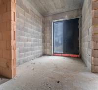 ATRAKTÍVNA MODERNÁ 5 IZB.ROZOSTAVANÁ VILA na KOLIBE - Stavebný priestor v rodinnom dome s pohľadom na betónovú podlahu a veľké dvere.