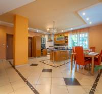 ,,,EXKLUZÍVNE,,,PREDAJ PRIESTRANNÉHO 5 IZB.RD V PEZINKU / LIMBACH - Interiér rodinného domu s kuchyňou, jedálenským stolom a oranžovými stenami.